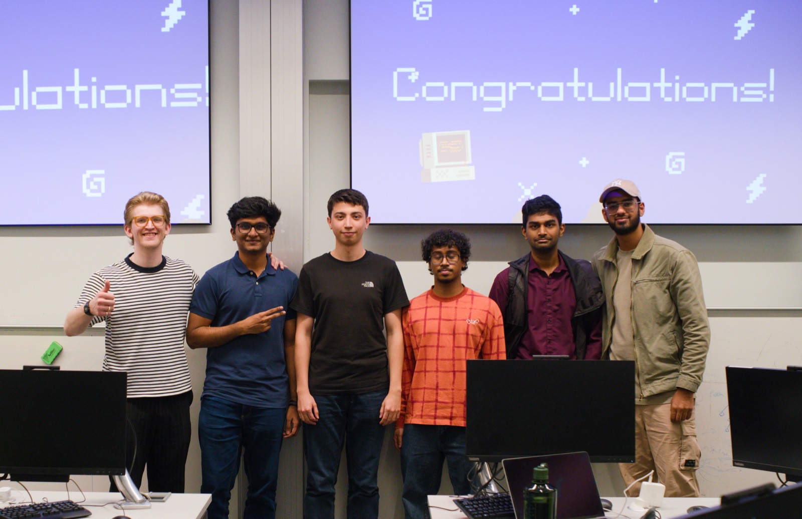 A winning team lined up in front of the congratulations screen