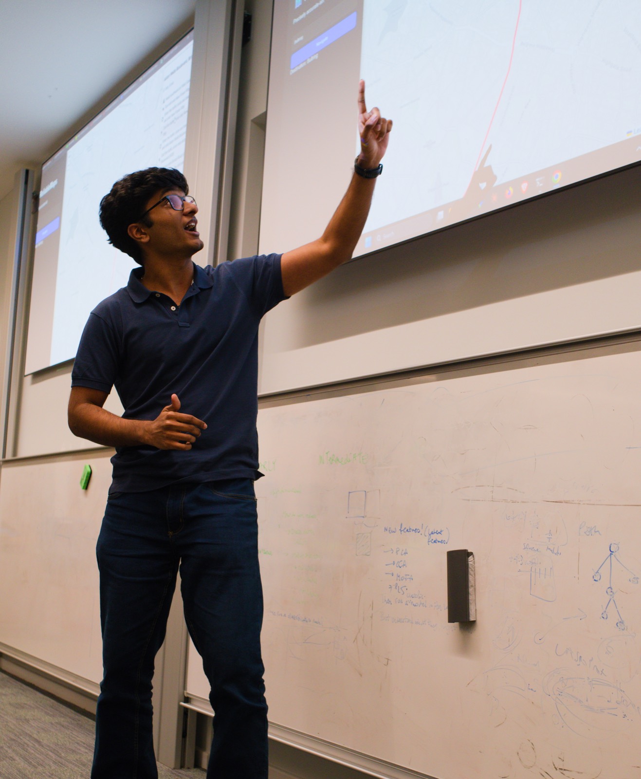 A member pointing at their prototype on the projector during a demo