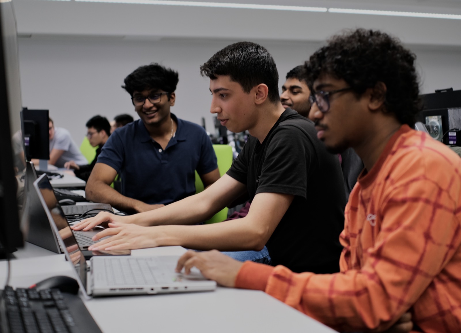 Three members concentrating on laptops side by side