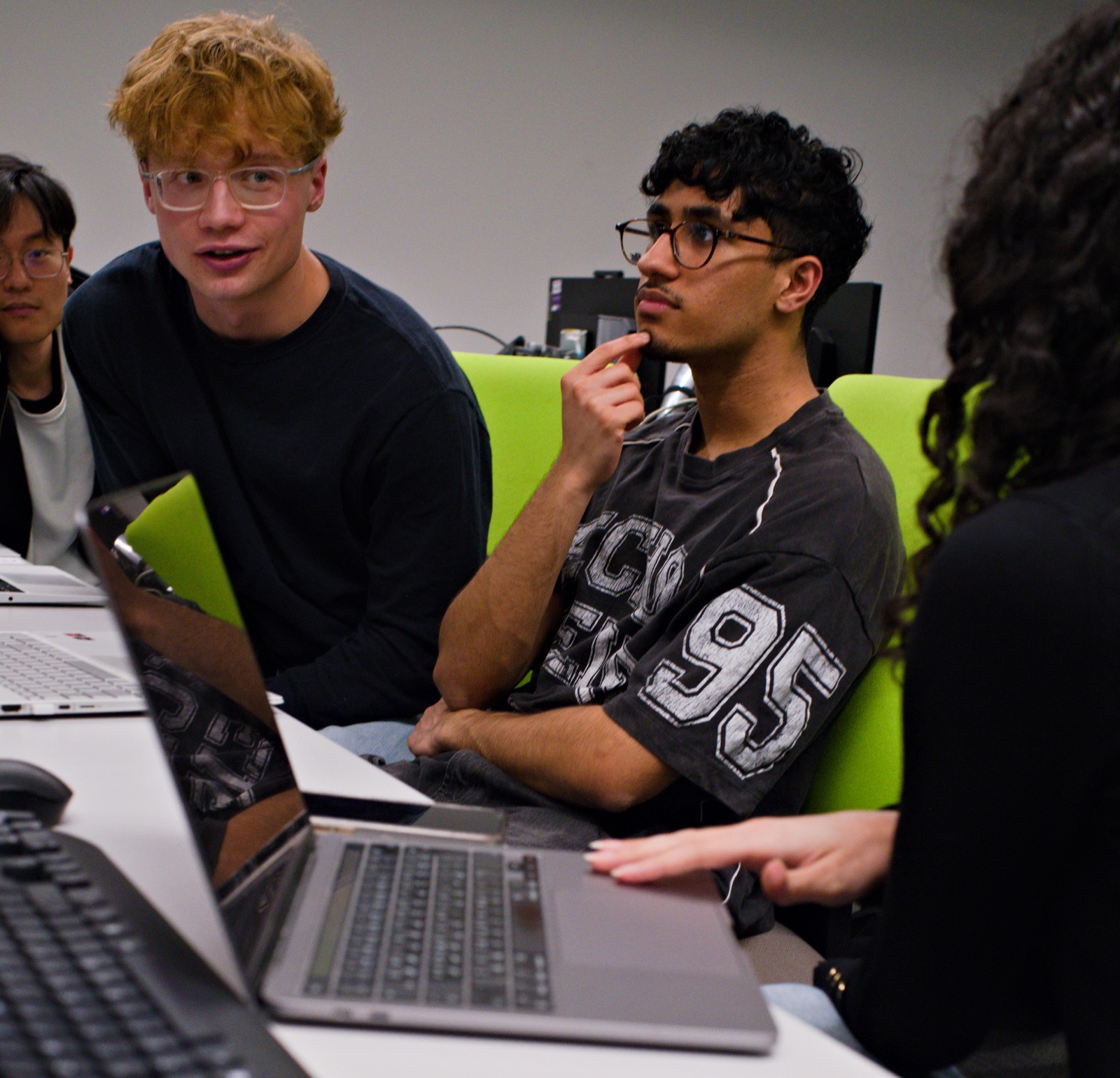A team of members talking through a problem together at their desks